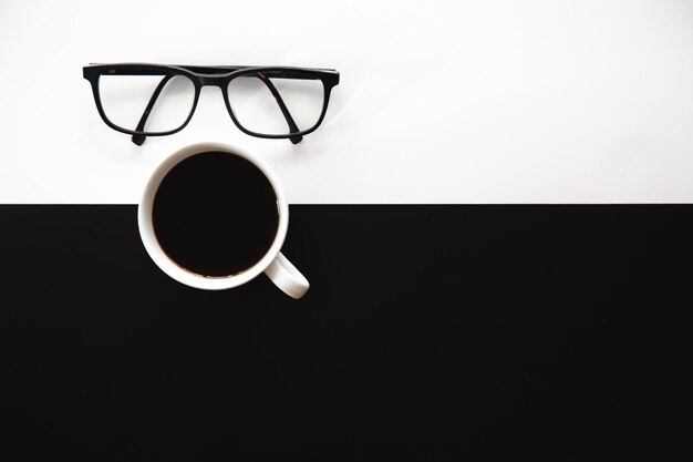 Cup of coffee on a black and white background flat lay