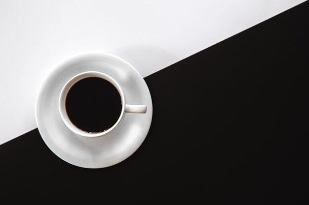 Cup of coffee on a black and white background flat lay