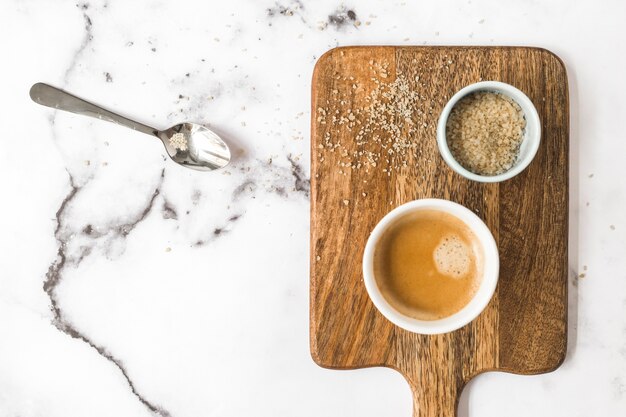 白い大理石の背景にコーヒーと砂糖のボウルのカップ