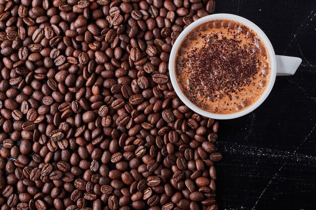 A cup of coffee on brown beans.