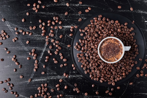 Free photo cup of coffee on brown grains.