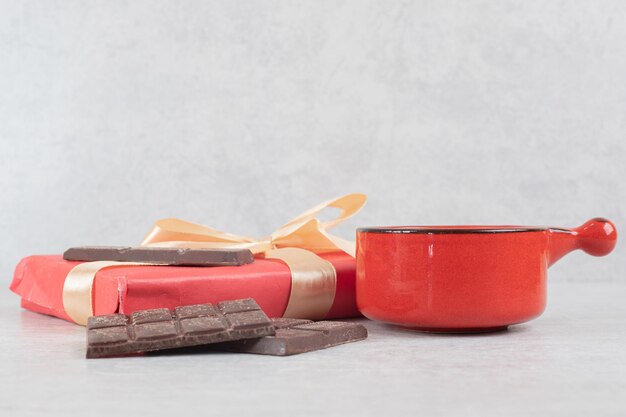 Cup of coffee, chocolate and gift box on marble surface