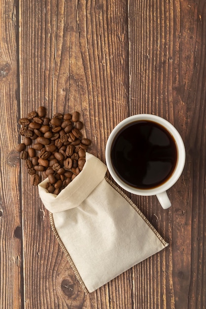 Cup of coffee and cloth bag with coffee beans