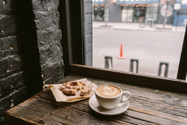 無料Photo 窓辺に置かれたクッキーの横にある一杯のコーヒー