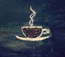 Free photo cup of coffee drawn on a blackboard with coffee beans