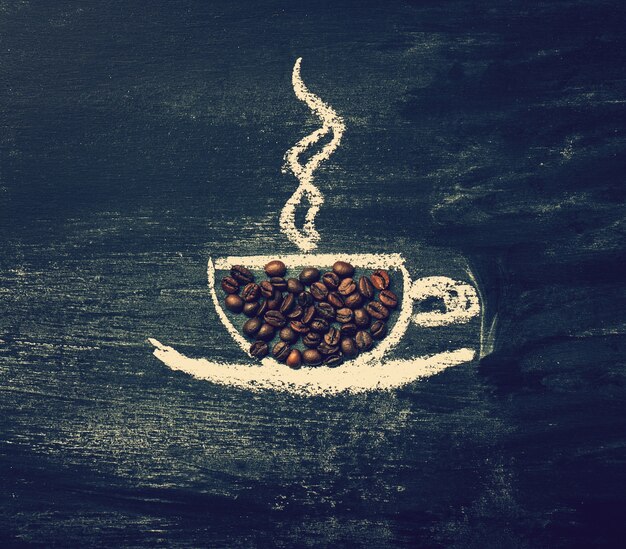 Чашка кофе нарисованы на доске с кофе в зернах