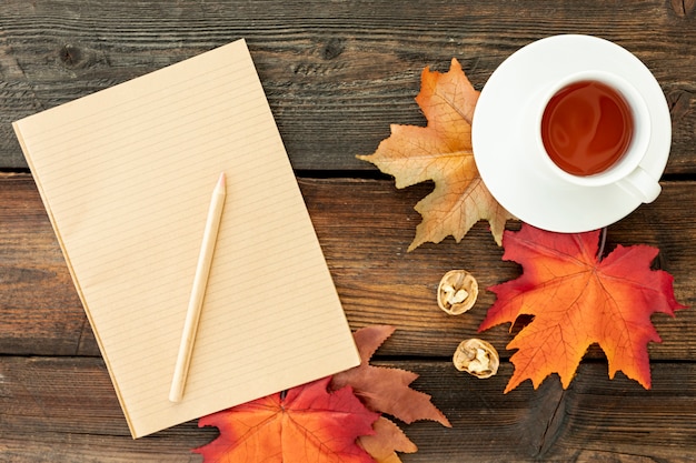 Cup of coffee next to empty notebook