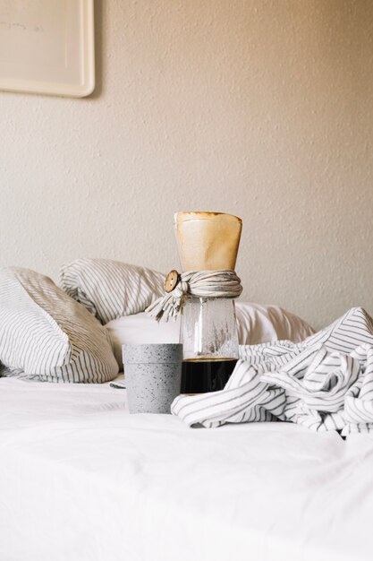 Cup and coffee jug on bed