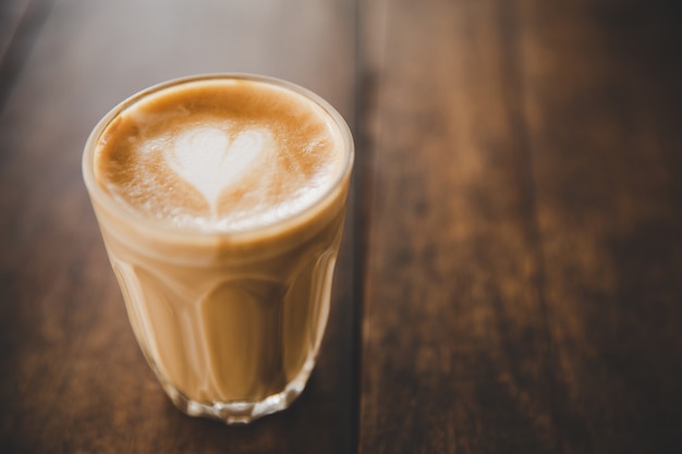 コーヒーショップカフェの木のテーブルにコーヒーのラテカップ