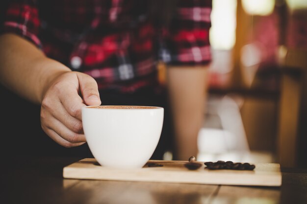 コーヒーショップカフェの木のテーブルにコーヒーのラテカップ