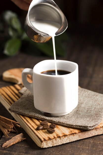 Cup of coffee and milk in kettle