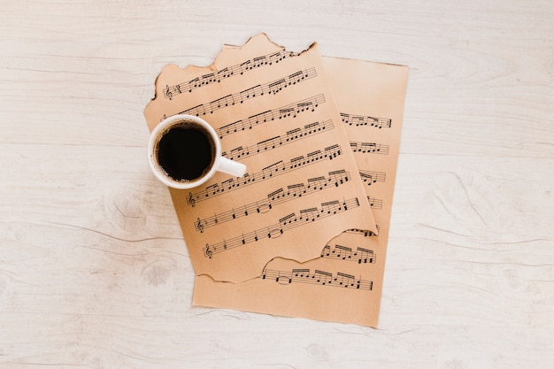 Free photo cup of coffee near sheet music