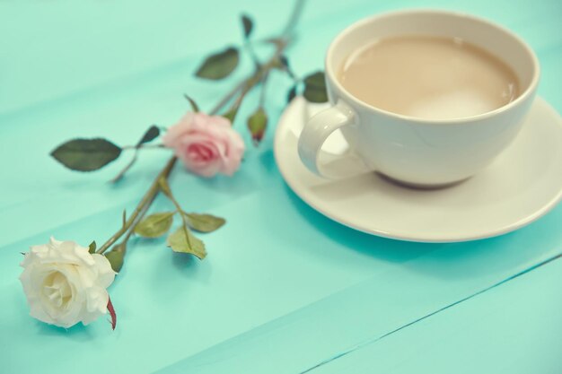 春の新鮮な花と古い木製のテーブルトップビューのコーヒーのカップ
