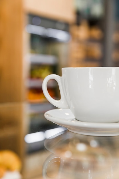 Cup of coffee on reflective coffee counter