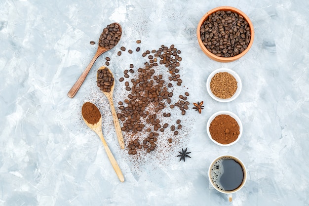 Cup of coffee, spices, and coffee beans in a bowl