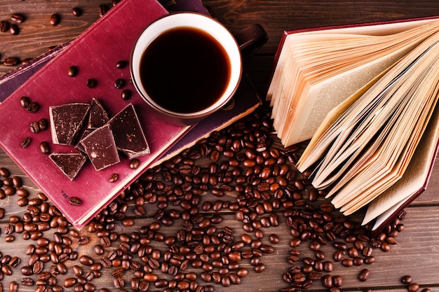Чашка кофе стоит на книжке с шоколадом