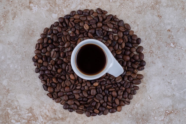Una tazza di caffè circondata da chicchi di caffè