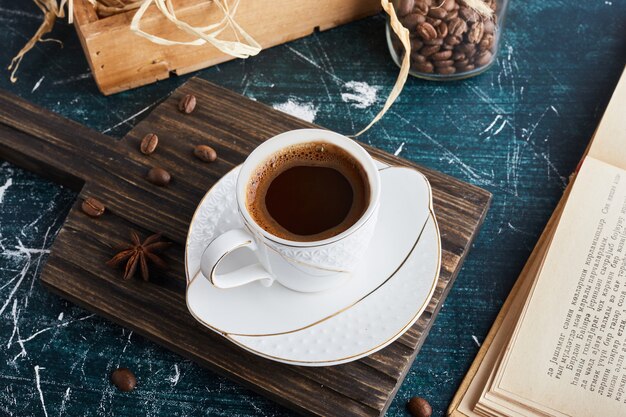 A cup of coffee in a white saucer.