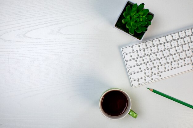 一杯のコーヒーワイヤレスキーボードと植物