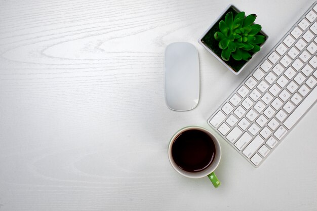 Чашка кофе и беспроводная клавиатура с мышью