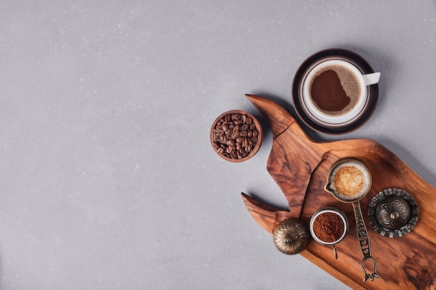 A cup of coffee with arabica and powder around.