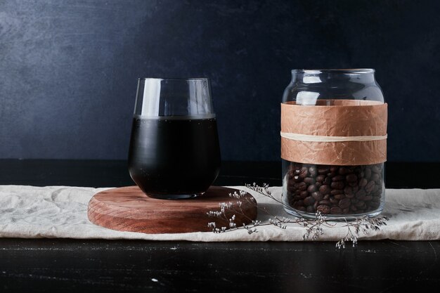 Cup of coffee with beans in the jar.