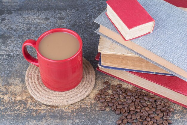 大理石の本とコーヒー豆とコーヒーのカップ。