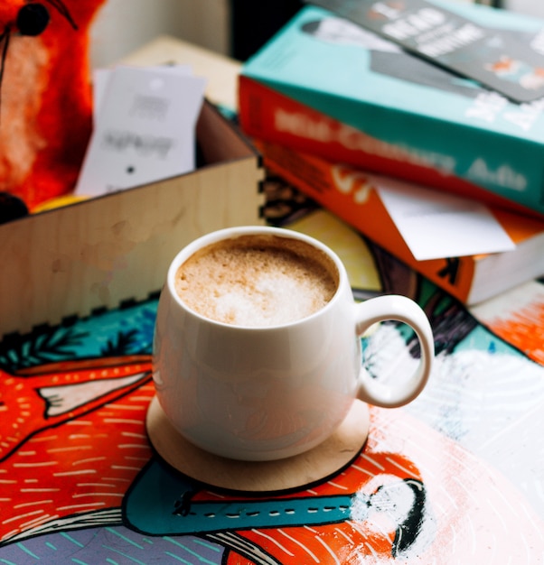 A cup of coffee with books on the table