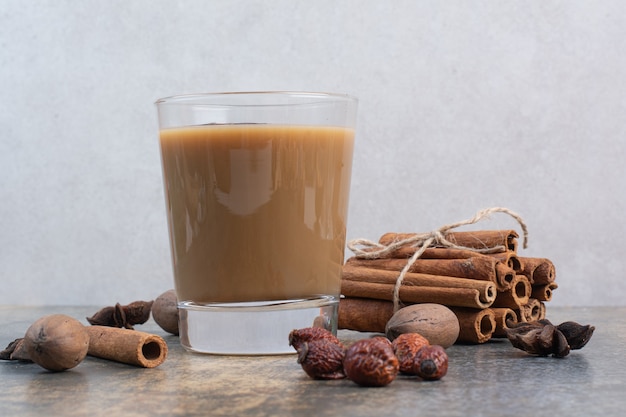 Cup of coffee with cinnamon sticks on marble background. High quality photo