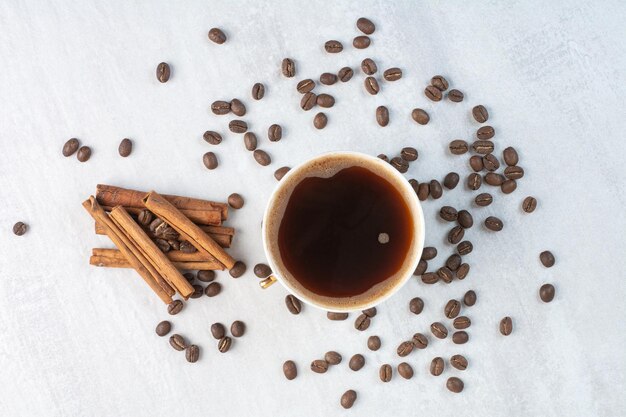 Cup of coffee with coffee beans and cinnamon sticks. High quality photo