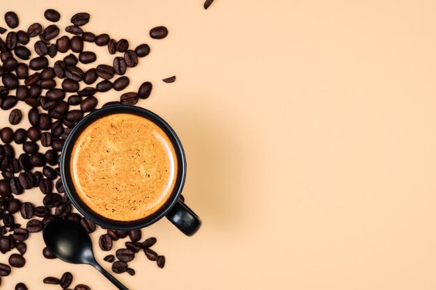 Чашка кофе с кофейной пенкой и кофейными зернами на пастельном фоне персикового цвета. Креативный макет. Концепция завтрака. Вид сверху, плоская планировка