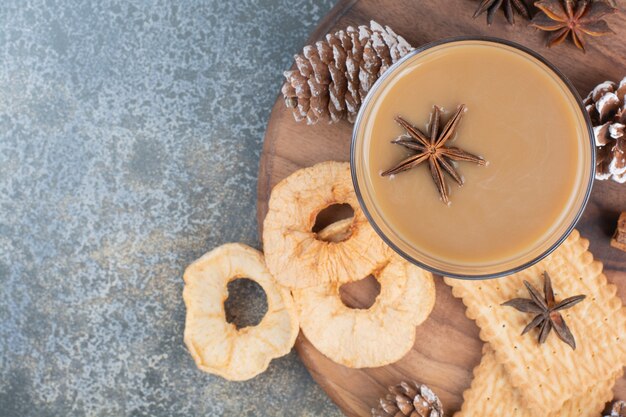 Cup of coffee with cookies and pinecones on wooden plate. High quality photo