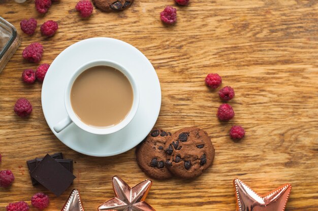 쿠키와 커피 한잔; 나무 테이블에 라스베리와 초콜릿 바 조각