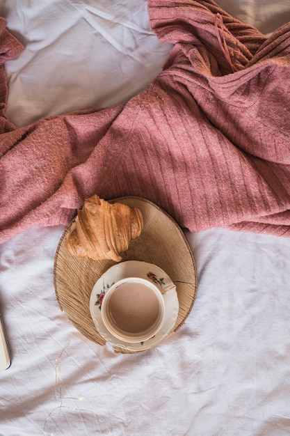 Foto gratuita tazza di caffè con croissant sul vassoio