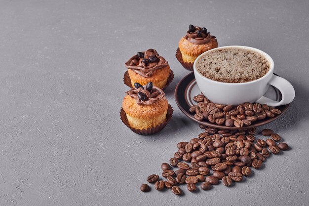 A cup of coffee with cupcakes.