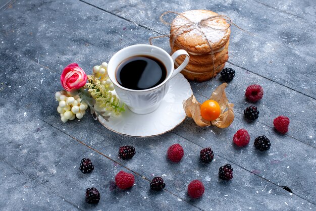 cup of coffee with different berries and creamy sandwich cookies on grey, berry fruit coffee drink