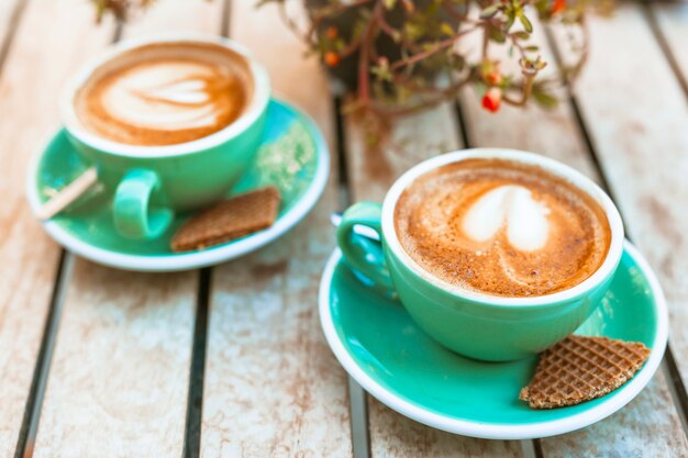 Cup of coffee with heart shape latte art on wooden table