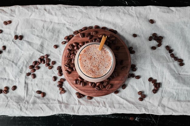 A cup of coffee with milk on a wooden board