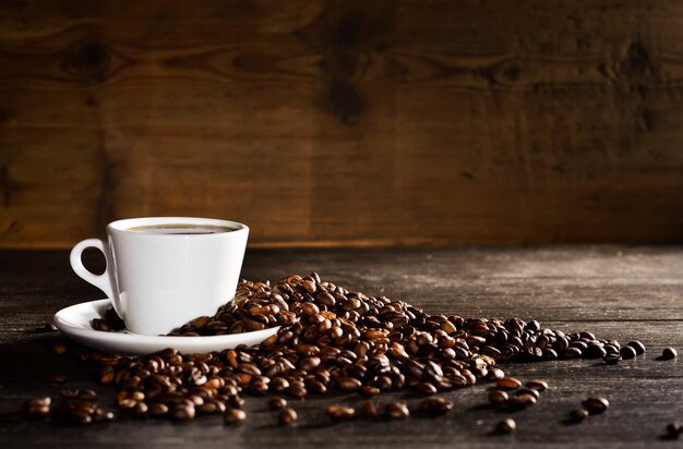 コー​​ヒー豆の山とコーヒーのカップ