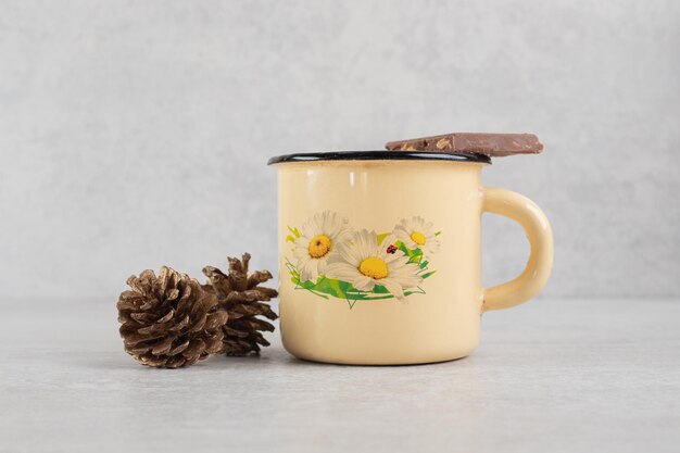 Cup of coffee with pinecones and chocolate bar