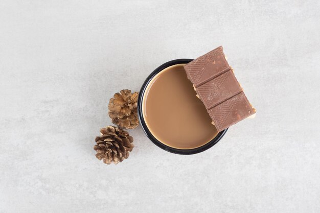 Cup of coffee with pinecones and chocolate bar