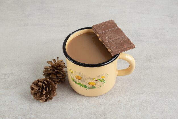 솔방울과 초콜릿 바가 있는 커피 한 잔