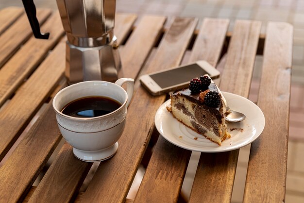 Cup of coffee with a slice of cake on table