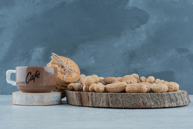 Una tazza di caffè con vari dadi e biscotti