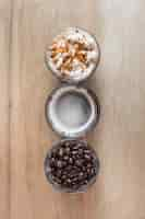 Free photo cup of coffee with whipped cream and roasted coffee beans on wooden backdrop