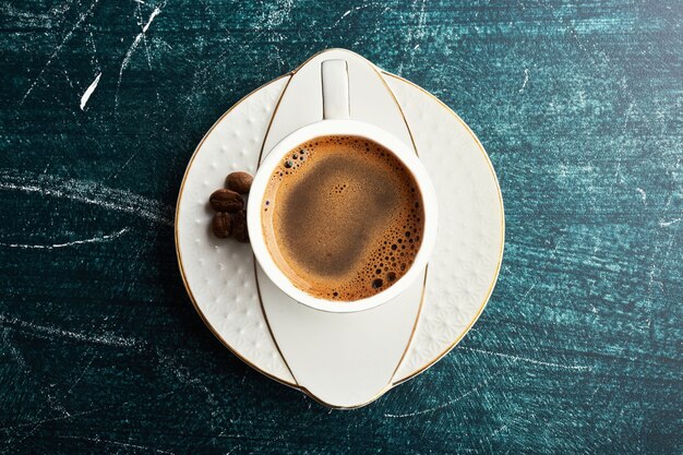 A cup of coffee with in a white saucer. 