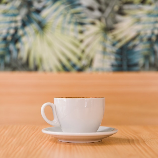 Cup of coffee on wooden desk