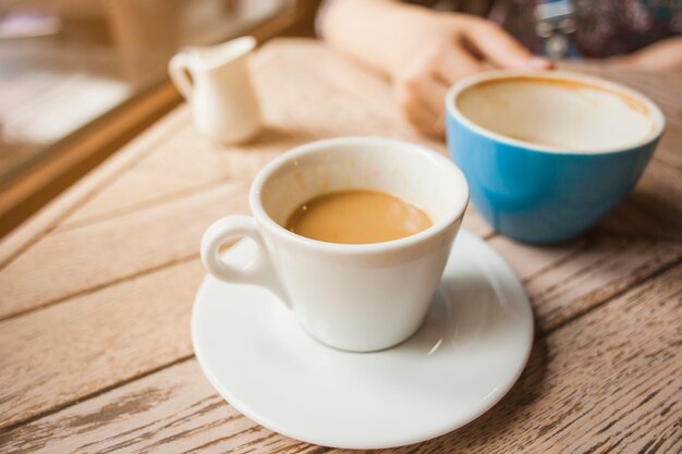 Cup of coffee on wooden table in cafeteria