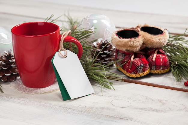 Чашка кофе на деревянном столе с пустым пустым ценником и рождественскими украшениями. Рождественский макет концепции