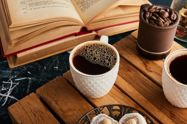 A cup of coffee on wooden tray.